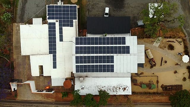 Vista aérea de um imóvel com telhados metálicos cobertos por várias fileiras de placas solares